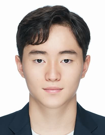 Young East Asian man with dark wavy hair wearing a dark suit jacket.